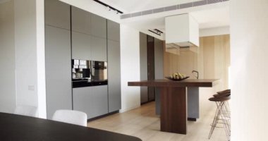 Yeni moda mobilyalarla dolu güzel bir mutfak. Lüks evde modern iç mekan. Minimalist bir mutfağın içinde. Açık Ahşap Duvar ve Zemin. Minimalist yemek masası olan modern mutfak odası..