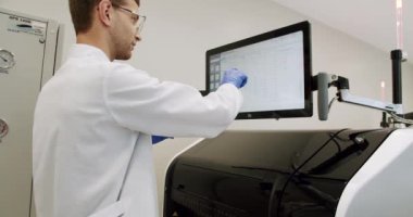 Blood Test Machine with tubes. A blood test with computer equipment. Blood Testing Machine Checks Samples In A Laboratory Room. Automated machine in work process, blood and urine sampleanalysis.