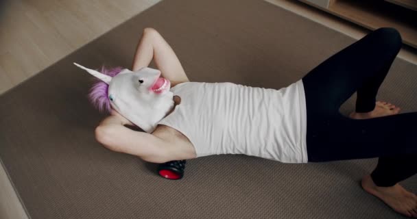 Vtipný Muž Maskou Jednorožce Cvičí Vzadu Válečkem Pro Myofáziální Relaxaci — Stock video