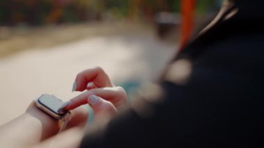 Atletizm yapan bir bayan sporcu, dışarıda yapılan kardiyo antrenmanı sırasında kalp atışlarını kontrol eder. Genç bir bayan atletizm ilerlemek için akıllı saati kullanıyor. Sağlıklı yaşam tarzı kavramı