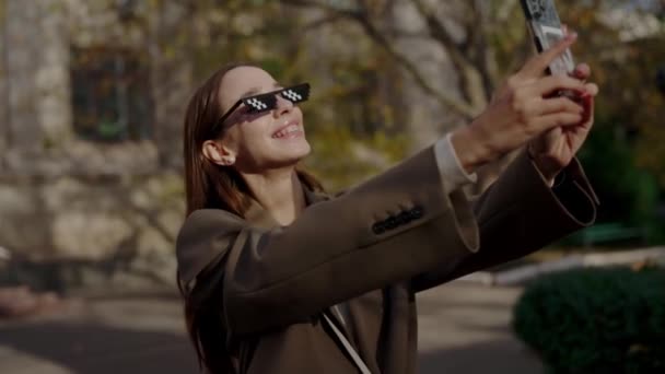 Cheerful Female Stylish Sunglasses Make Selfie Smartphone While Walking City — Stock Video