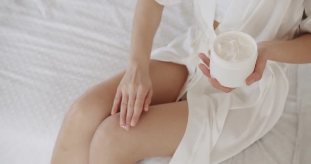 足の柔らかく滑らかな肌のために水和クリームを使用して女性のクロップビュー シャワー後に体に保湿剤を塗布する女性 ボディケアコンセプト — ストック動画