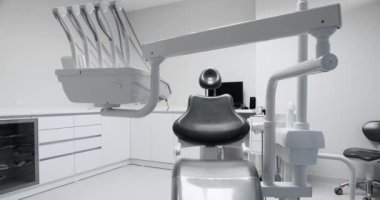 Modern iç mimarisi olan dişçi bürosunda stomatolojik koltuk. Hastanedeki tıbbi malzemelerle dolu boş bir dişçi dolabı. Sağlık ve ağız bakımı kavramı