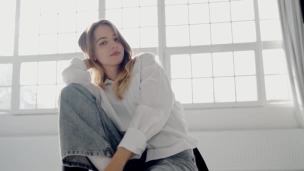 Stilfuld Kvinde Jeans Hvid Skjorte Sidder Poserer Kameraet Studieoptagelserne Attraktiv – Stock-video