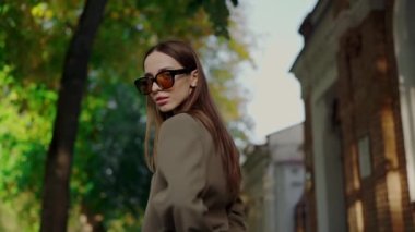 Kadın gözlüğü şehir sokaklarında yürürken sonbahar moda gösterisi. Sonbahar moda karışımı zarafet. Sonbahar modası güzel kıyafetler şık insanlar..