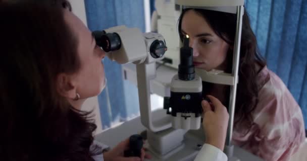 眼科医のクローズアップ患者による屈折計による視力検査 目の健康の重要性を強調する眼科医療のための近代技術を使用して眼科検査クリニックに不可欠なビジョンテスト — ストック動画