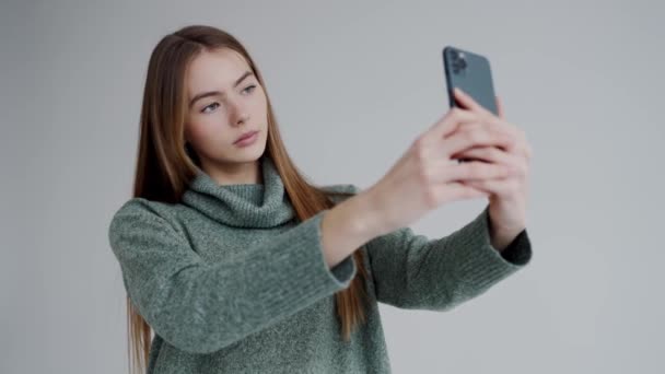 Hermosa Mujer Joven Tomando Fotos Misma Teléfono Sobre Fondo Blanco — Vídeos de Stock