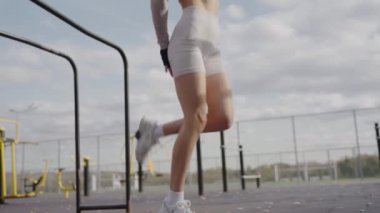 Atletik vücutlu, fiziksel egzersiz yapan ve sokağa atlayan genç bir kadın. Sportif dişiler dışarıda antrenman yapar. Aktif ve sağlıklı yaşam tarzı kavramı