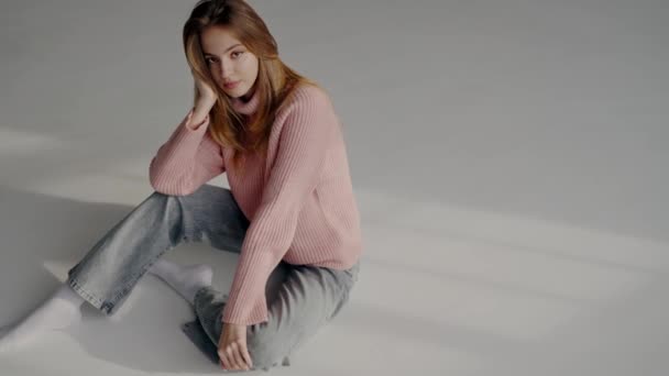 Incantevole Modella Donna Maglione Maglia Rosa Jeans Seduta Sul Pavimento — Video Stock