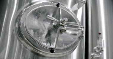 Stainless steel tanks for brewing beer. Huge stainless vats in a brewery. Equipment for beer fermentation. Brewing equipment. Factory, brewery concept. Modern brewery.