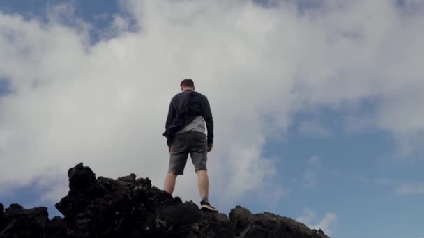 Video Que Muestra Hombre Pie Cima Una Escarpada Montaña Rodeado — Vídeo de stock