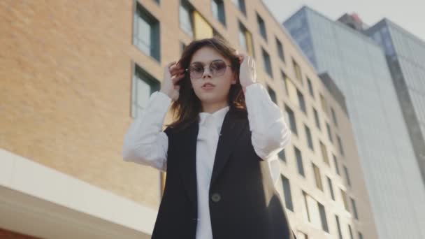 Una Mujer Ropa Formal Incluyendo Una Chaqueta Gafas Sol Está — Vídeos de Stock
