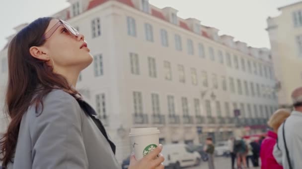 一个视频记录了一个女人站在街上 手里拿着一杯咖啡 站在街上举杯咖啡的妇女 — 图库视频影像