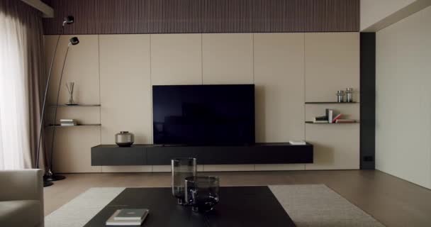 ハードウッドフローリング キャビネット フラットスクリーンテレビが壁に取り付けられた居心地の良いリビングルームです コーヒーテーブルが部屋の中央に座っている — ストック動画