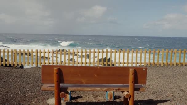 海の美しい景色を望む海辺の空の木製ベンチ 自然を楽しむこと 波の水と地平線で海を眺めることができます 屋外の座席の場所 — ストック動画