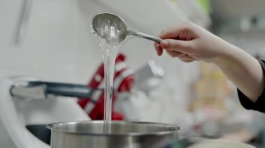 Kadın şefin el ele tutuşması ve pasta pişirmek için jelatinin hazır olup olmadığını kontrol etmek. İşçi kafe mutfağında tatlılar için jelatin hazırlar
