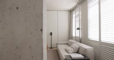 Modern oturma odası. Lüks minimalist tasarım, beyaz ve gri tonlu gerçek daire, zarif sandalye ve lüks mobilyalar, beyaz halı ve siyah ses teknikleri, beton, minimalist tasarım
