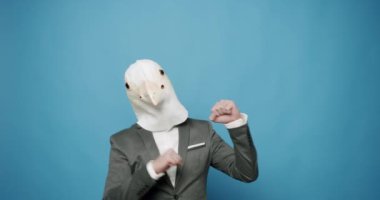 Güvercin maskeli adam komik hareketler yapıyor. Güvercin Maskeli Adam. Eğlence ve mutluluk kavramı. Gri Takım Elbiseli Komik Adam Güvercin Maskesiyle Dans, Eğleniyor, Parti Cadılar Bayramı. Ağır çekim. Maskaralık fikri.