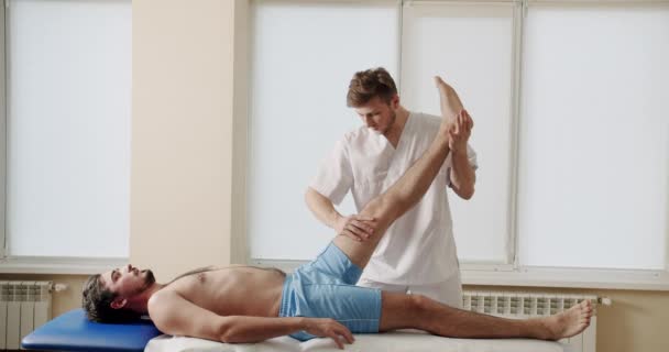 骨科医生在康复中心为男性病人做康复运动 男性运动员在临床上与脊椎按摩师进行物理治疗 卫生保健概念 替代疗法 — 图库视频影像