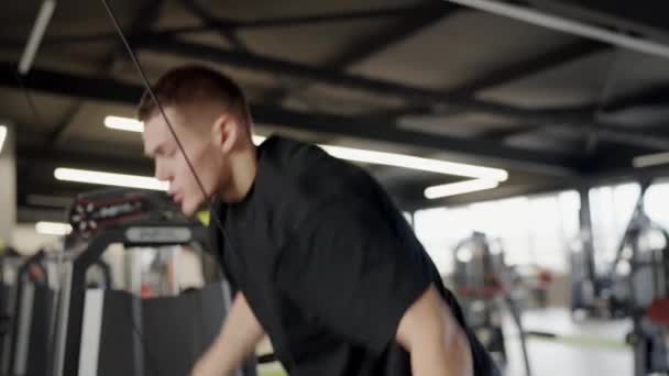Een Man Traint Een Machine Sportschool Omringd Door Metalen Apparatuur — Stockvideo
