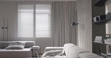 Modern oturma odası. Lüks minimalist tasarım, beyaz ve gri tonlu gerçek daire, zarif sandalye ve lüks mobilyalar, beyaz halı ve siyah ses teknikleri