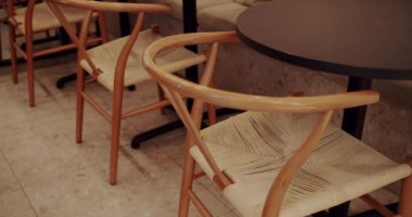 Ahşap sandalyeli, tekstil malzemeli ve siyah masalı modern minimalist kafe. Eco Friendly Cafe. Boş yemek kumaşı ve tahta sandalye. Kafede modern ahşap kumaş sandalye ve masa mobilyası..