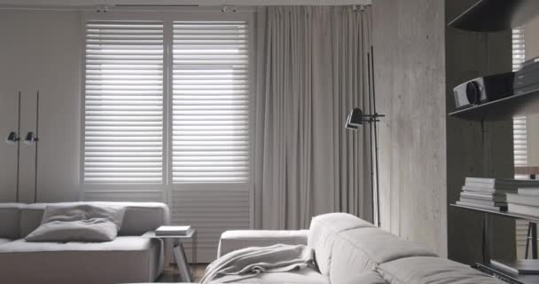 現代のリビングルーム 豪華なミニマリストデザイン 白とグレーの色調の本物のアパート 優雅さの椅子と豪華な家具 白いカーペットと黒のオーディオ技術 — ストック動画