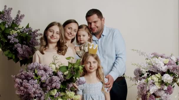 Οικογενειακό Πορτραίτο Που Στέκεται Για Φωτογραφία Μέσα Λευκό Φόντο Λουλούδια — Αρχείο Βίντεο