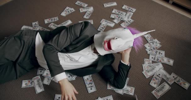 ユニコーンマスク付きビジネスマン スタックキャッシュマネードル収入 職場での給与収入 給料や利益の概念について ユニコーンのマスクを持つハンサムな幸せなビジネスマンはドルをスキャンします — ストック動画