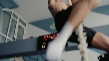 Sporcu adam spor salonunda fiziksel egzersiz yapıyor ve ipe tırmanıyor. Sportif erkek spor salonunda antrenman yapıyor. Spor ve aktif yaşam tarzı kavramı