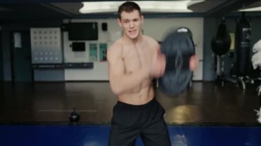 Genç atletik adam spor yapıyor ve modern spor salonunda demir halterli kreple egzersiz yapıyor. Spor malzemeleriyle antrenman yapan sporcu.