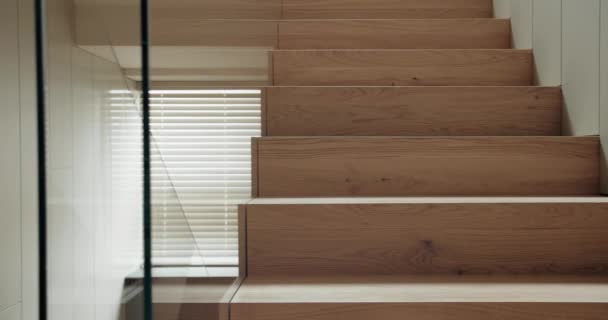 近代的な家 木製の階段および窓の内部の細部は屋内で盲目にします スタイリッシュなアパートの天然木材から現代的な階段 — ストック動画