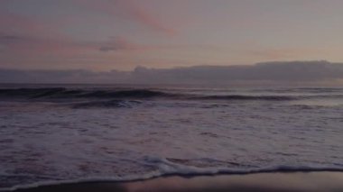 Gün batımında güzel deniz manzarası, deniz dalgaları ve kumlu sahil. Yaz günü okyanus manzarası