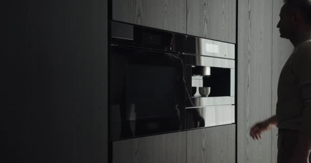 在现代厨房的木柜里 人们用咖啡机准备新鲜咖啡 男人早上在家里做浓缩咖啡 时尚公寓的家用电器 — 图库视频影像