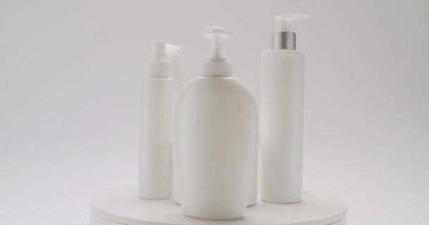 在工作室里 白色的瓶子和管子在白色的背景上旋转用于化妆品 化妆品用油是以天然成分 洗涤剂 护肤为基础的 天然护发素和护肤化妆品生产 — 图库视频影像