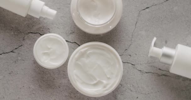 Białe Słoiki Tuby Kosmetyków Obracają Się Szarym Betonowym Tle Studio — Wideo stockowe
