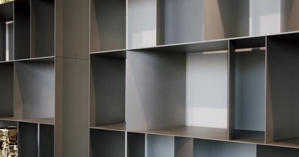 アパートのリビングルームの壁の近くの木製の空の本棚の閉鎖 現代家具 スペースを整理するための本棚 — ストック動画