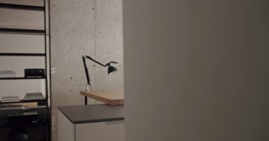 Minimalist bir dairede modern mutfak odası. Yemek alanı doğal ahşap. Kara Mutfak lavabosu ve musluğu var. Evin içi beyaz, gri renkler, beton ve konforlu ekipmanlar..