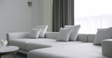 Beyaz, gri mobilyalı ve yuvarlak masalı modern Minimalist oturma odası. Köşedeki kanepe ve kitaplığı olan lüks modern ev iç mimarisi. Moda mobilyalar. Lüks Zarif Oda
