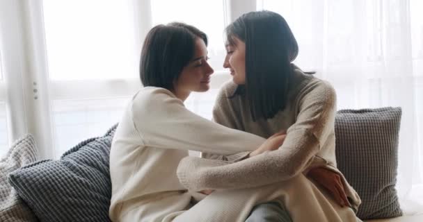 カップル Lgbt レズビアンの女性が自宅にいる お互いに抱き合い 抱き合っている Lgbtの権利 レズビアン ファミリー 若いレズビアンカップルの低角度のハンドヘルドショット笑顔と優しく手に触れる — ストック動画