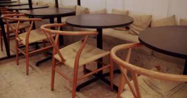 Ahşap sandalyeli, tekstil malzemeli ve siyah masalı modern minimalist kafe. Ahşap sandalye ve masayı kapat. Eco Friendly Cafe. Kafede modern ahşap kumaş sandalye ve masa mobilyası..