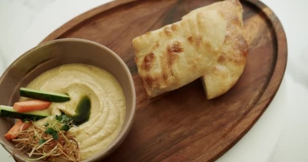 Hummus Delicioso Uma Tigela Marrom Com Pepinos Vegetais Frescos Cenouras — Vídeo de Stock