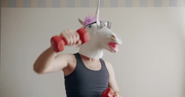 Vicces Ember Egyszarvú Maszkkal Napszemüveggel Aki Otthon Gyakorolja Súlyzókat Fehér — Stock videók
