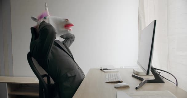 一个戴着独角兽面具 身穿西装的有趣男人 享受着他的经济成功 并在办公室数钱 穿着西装的满意的老板算计利润 薪金或利润的概念 — 图库视频影像