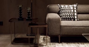 Yastıklı tekstil döşeme kanepesi. Modern apartman güzel bej kanepe modern oturma odasında lamba, halı, masa. Ahşap duvarlı İskandinav iç mimarisi. Modern gri ve bej kumaş kanepe