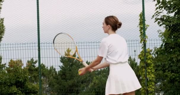 女人在室外地毯场上打网球 一个女人专业地 动态地打网球 赢了这场比赛周末和周日的娱乐活动 与朋友一起积极运动 — 图库视频影像