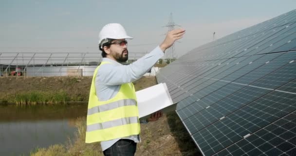 Positive Adult Man Uniform Checking Photovoltaic Panels Making Notes Journal — Vídeo de Stock