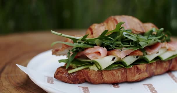 サンドイッチのクローズアップを施したプレートで 主食を披露します サンドイッチは新鮮な農産物で飾られ テーブルに提示されます — ストック動画