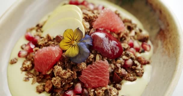 조용하고 세련된 비디오 그라노라 꽃으로 요구르트의 그릇을 보여줍니다 음식과 생활양식 — 비디오
