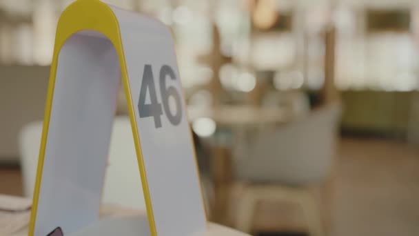 餐桌上的餐台上摆着号码 餐厅内部的细节 选择餐桌编号 等待食物 — 图库视频影像